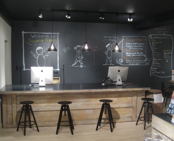 Children's retail store large chalkboard wall and custom transaction desk with stools