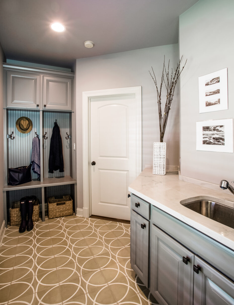 mudroom with built-in cabinets, grey cabinets, porcelain floor with circle pattern