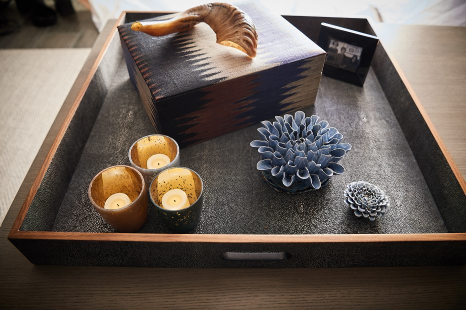 charcoal textured tray with candles, multi-colored box and blue ceramic flower