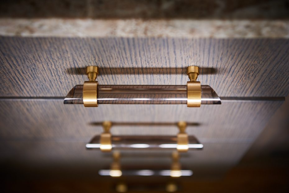 detail of brass and smoked lucite drawer pulls