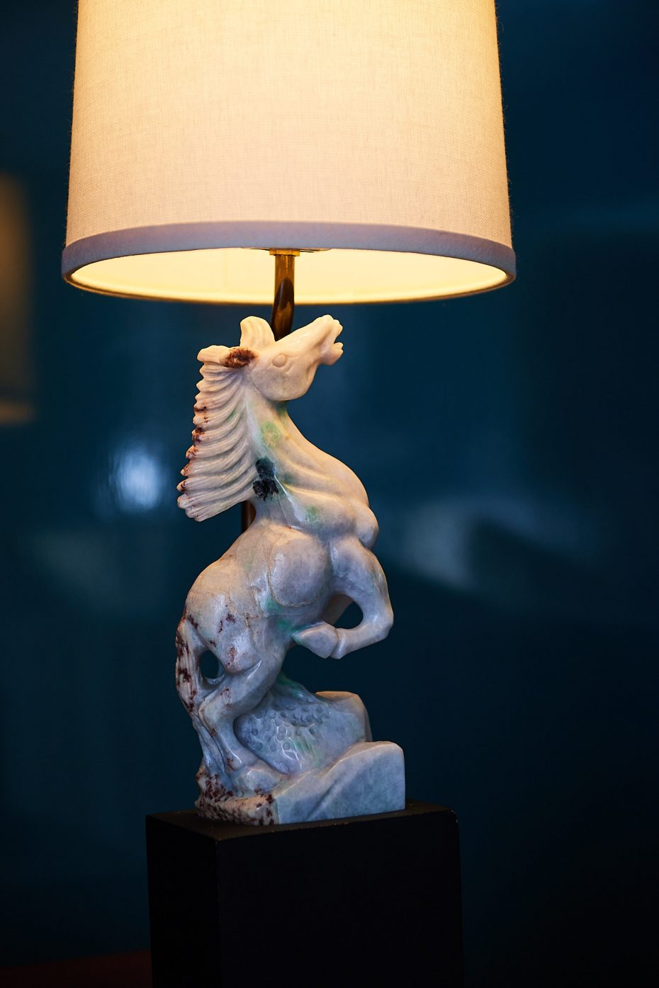 antique lamp with a white carved stone base of a horse