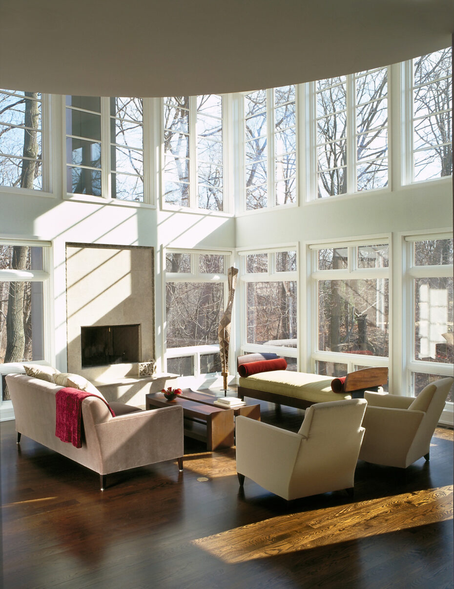 floor to ceiling windows in large modern living room with fireplace