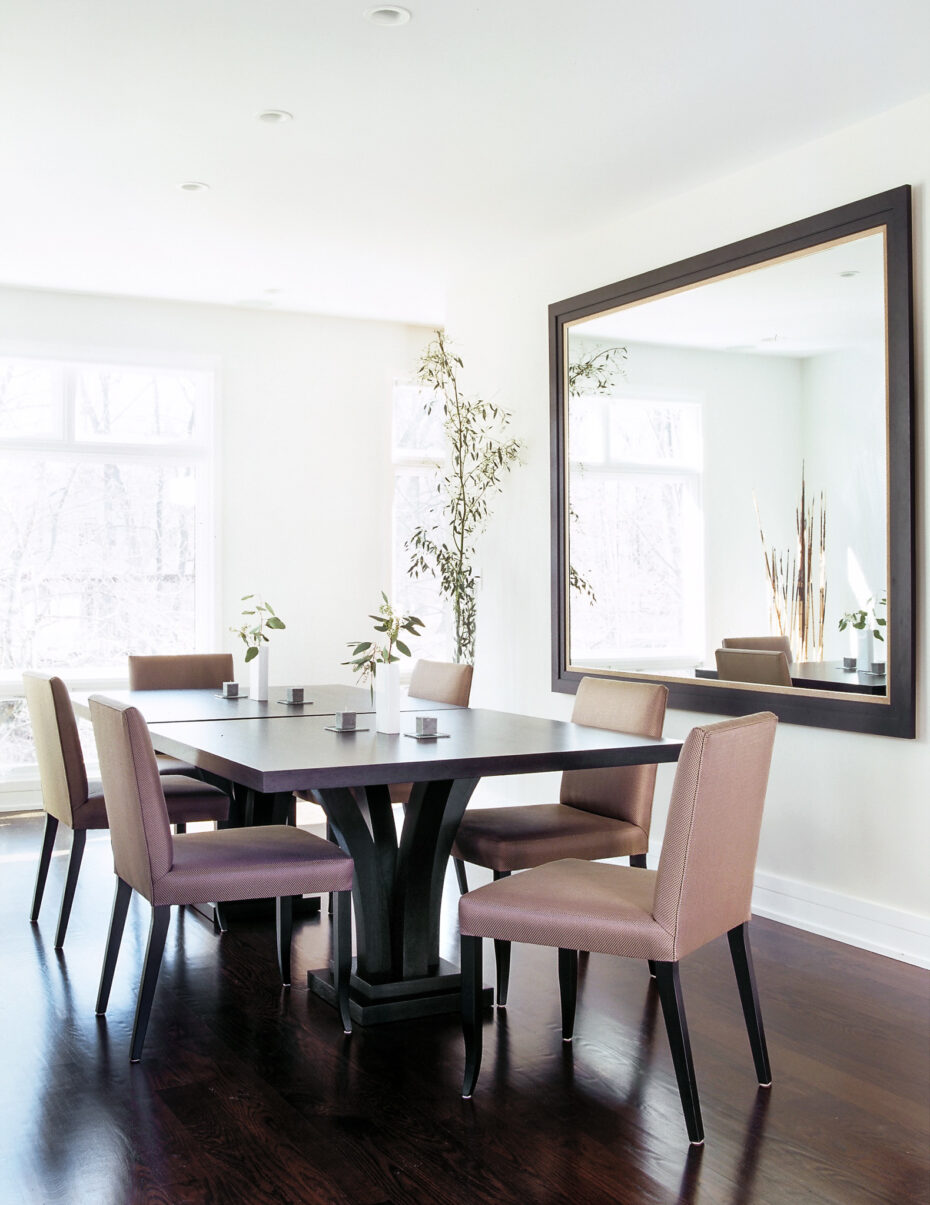 dining room with 2 square dining tables, plum colored chairs and a large mirror