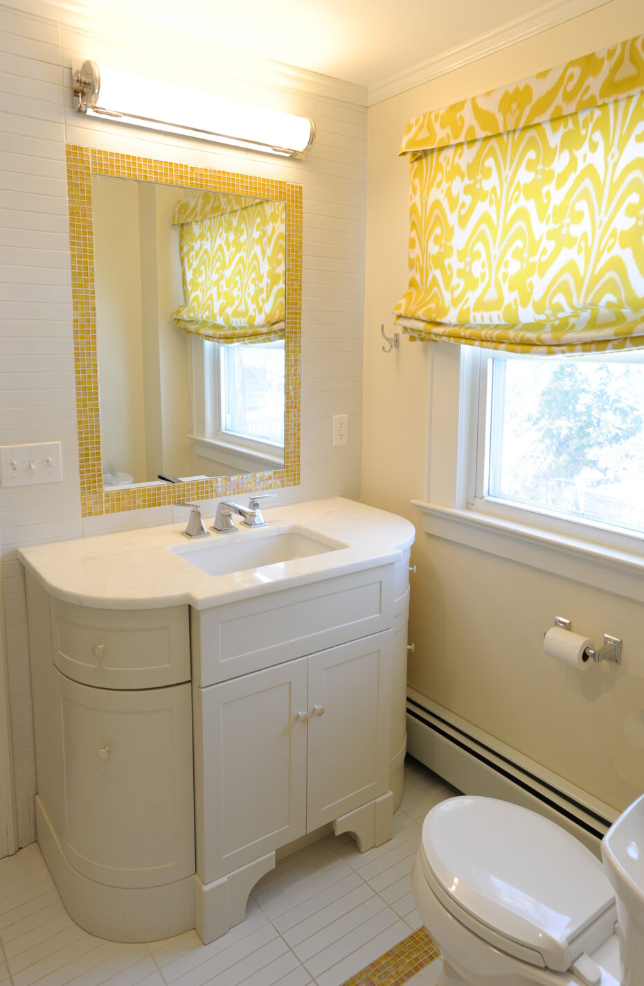 bathroom with white curved cabinet and yellow siccis glass tile