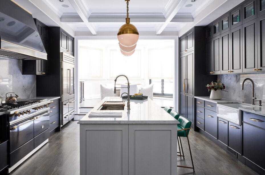 Black and White Kitchen. Island with Quartz stone top, brass lights, black appliances and green stools