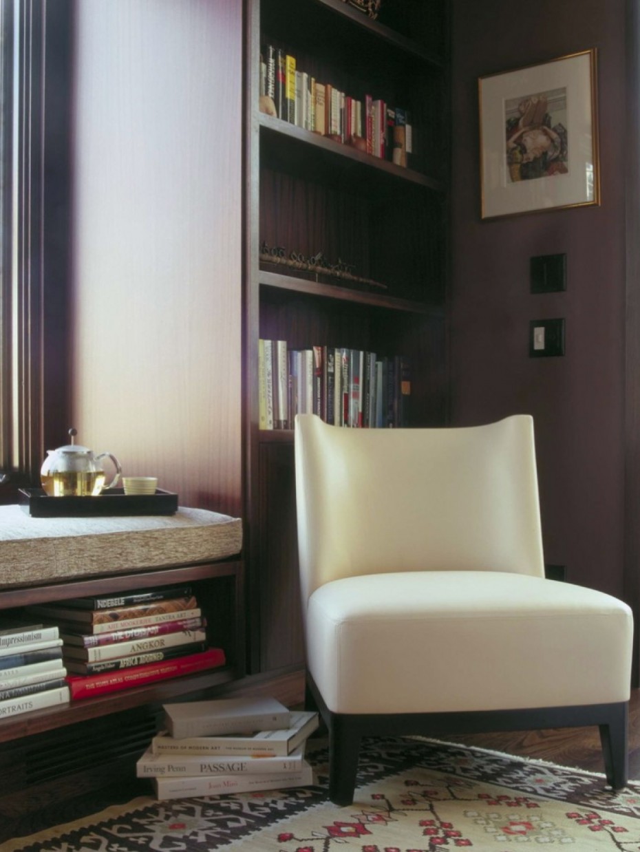 Christian Liagre Chair in white leather in dark paneled den with Kilim Rug